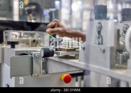 car wire harness factory, wiring cable measure in a machine, african american workers hand Stock Photo