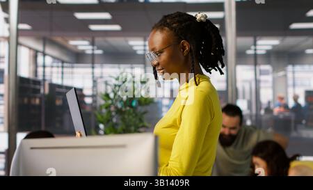 System administrator creating machine learning models that can process and analyze data to automate decision making processes. IT staff member using laptop to do programming in office, camera A Stock Photo
