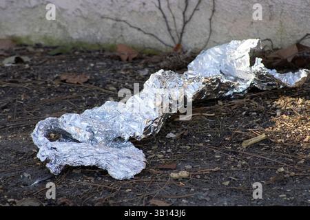 crumpled piece of tinfoil on ground Stock Photo