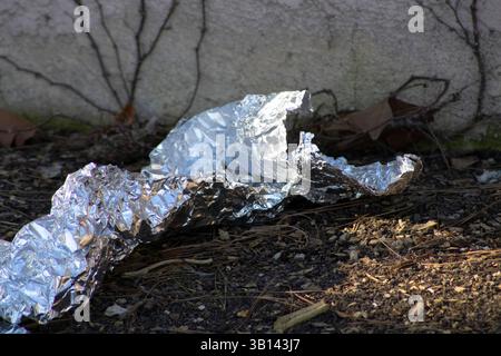crumpled piece of tinfoil on ground Stock Photo