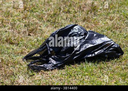 black trash bag in public park Stock Photo