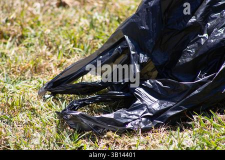 black trash bag in public park Stock Photo