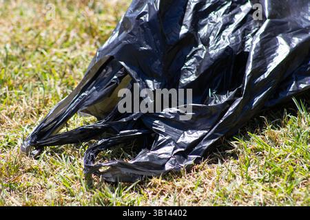 black trash bag in public park Stock Photo