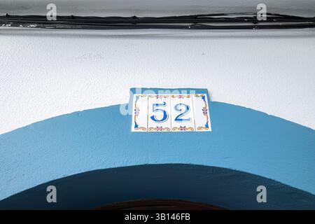 Traditional Portuguese Ceramic House Number Tile on Mediterranean Architecture. Decorative Blue and White Azulejo House Number 52 with Ornate Floral P Stock Photo