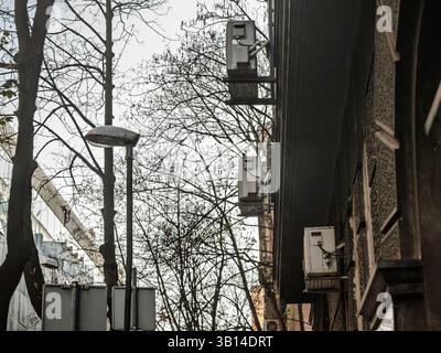 Row of ageing split‑system air‑conditioning units jut from a crumbling façade in central Belgrade, highlighting cooling dependence and energy loss in Stock Photo