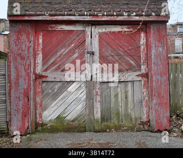 Old wooden garage with weather-beaten door Stock Photo