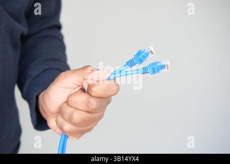 Holding multiple blue network cables for connection setup Stock Photo