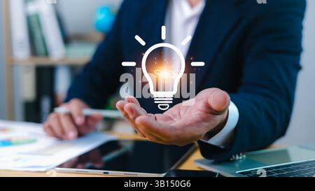 Innovation through ideas and inspiration ideas, Idea of creativity and inspiration concept of sustainable business development, Human hand holding lig Stock Photo