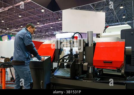 03/11/2025, Russia, novosibirsk,expocentre, welding exhibition, a worker at the cnc machine controls the process of work and production of parts, indu Stock Photo
