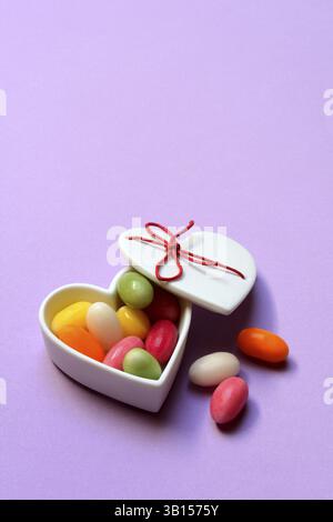 Colourful sugar eggs in a heart-shaped ceramic bowl, Easter eggs, sugar Easter eggs Stock Photo