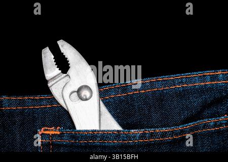 Pliers in Pocket, Close-up a of silver pliers sticking out of the back pocket of blue jeans. Hand tools, DIY, repair equipment. Stock Photo