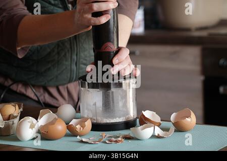 Preparing Eggshell Powder. Woman grinds eggshells with blender. Calcium supplement, cracked eggshell, natural compost ingredient, broken eggshell Stock Photo