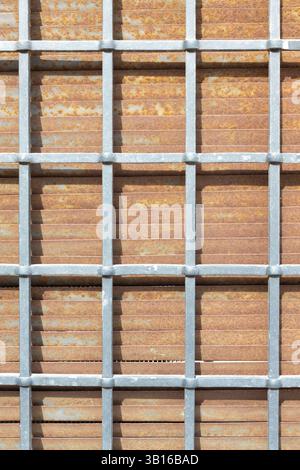 Metal grid structure over weathered rusted steel with industrial texture details Stock Photo