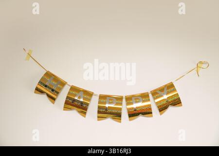Golden Happy word text on white background, minimal festive design with elegant lettering and bright mood Stock Photo