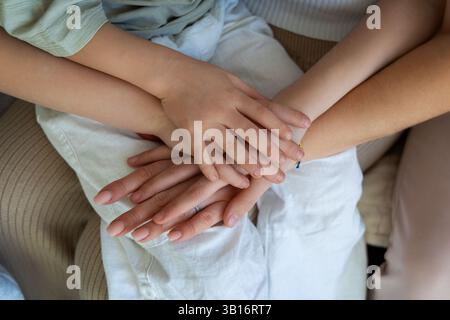 Stacked hands symbolizing family unity and love. Close-up of a family's hands stacked together, symbolizing love, support, and unity. Stock Photo