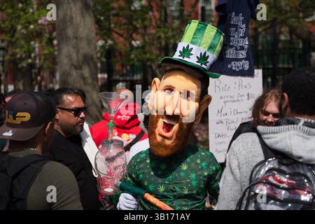 A person in a Lionel Messi costume, wearing a green hat with marijuana leaf designs, stands at an outdoor event.  They hold a glass bong.  People are Stock Photo