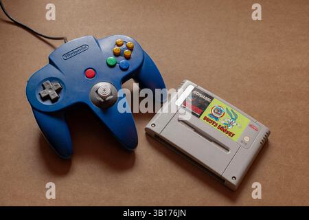 Nostalgic image of Nintendo console and "Tiny Toon Adventures" SNES video game cartridge, isolated on plain light background with copy space. Stock Photo