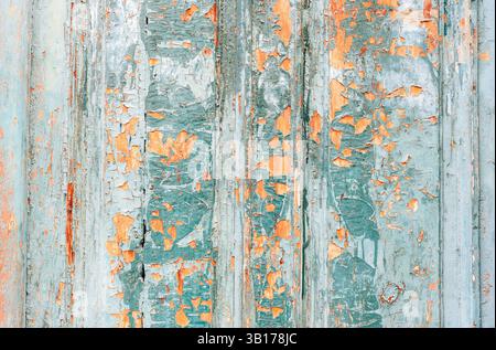 Close-up of old wooden surface with cracked peeling turquoise and orange paint. Texture, background. Stock Photo