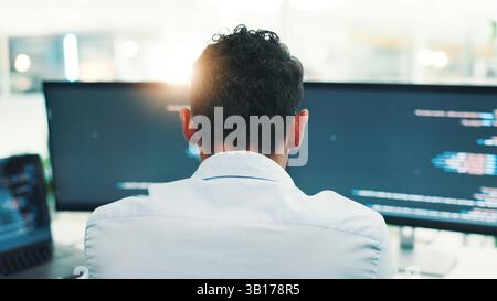 Programmer, man and computer screen with reading in office for writing code, planning digital software and debugging. Back, programming and employee Stock Photo