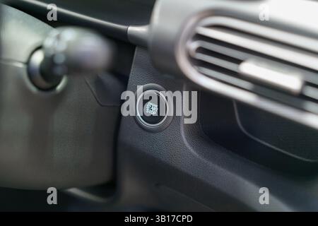 close-up of a push-to-start engine button on the car’s dashboard, highlighting keyless ignition, sleek design, and user-friendly technology. Stock Photo