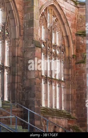 Sunlight streams through the intricate tracery of a Gothic window in the ruins of Coventry Cathedral, England, highlighting the resilience of its arch Stock Photo