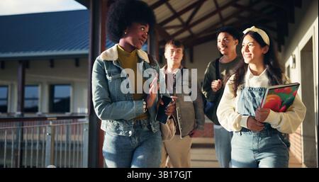 Friends, talking and students with walking in hallway for high school gossip, conversation and learning break. Education, people and happy with Stock Photo