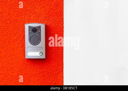Modern door intercom on red and white wall Stock Photo
