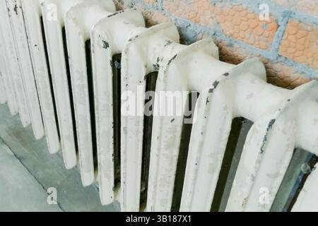 The old cast-iron heating radiator is in place of the new one during the construction of the house. Stock Photo
