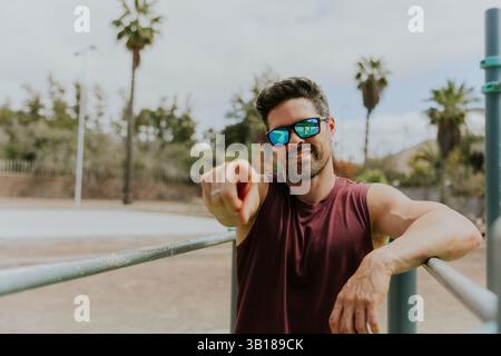 A fit 40 years old man points to the camera with his finger during a work-out, active lifestyle. Stock Photo