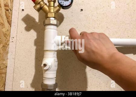 Faucet on a plastic heating pipe coming out of the boiler Stock Photo