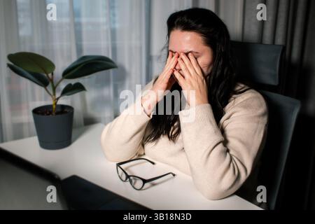 Tired Caucasian woman feeling stressed from work problems. Irritation burnout. Rubbing eyes. Dealing with work deadlines. Have not enough sleep. Stock Photo