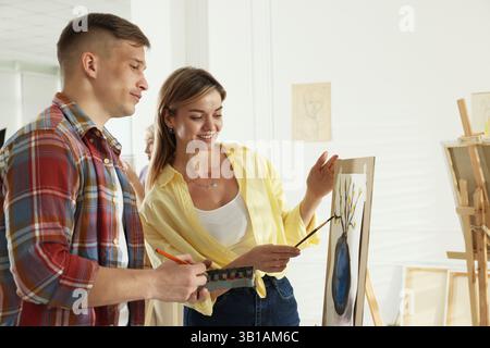Artist teaching her student to paint in studio Stock Photo
