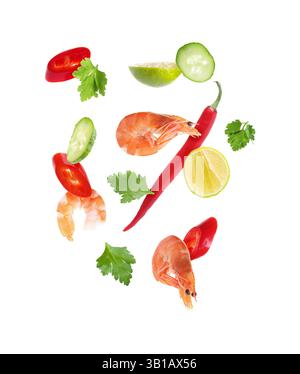 Pieces of fresh vegetables, lime and shrimps falling on white background Stock Photo