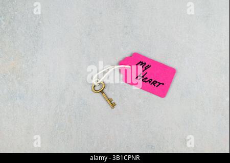 Antique key on string with pink tag - concept of key to my heart Stock Photo