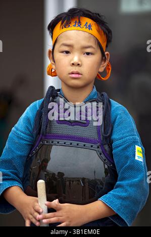 Member of the junior kendo team pretending to be a samurai warrior carrying a shinai (bamboo sword) participates in the Hikone Castle Festival, Japan. Stock Photo