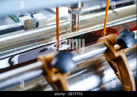 Efficient glue application in industrial machinery enhances precision in production processes Stock Photo