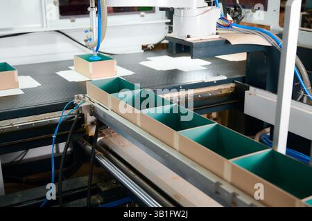 Robotic precision in box manufacturing process enhances efficiency in a modern production facility Stock Photo