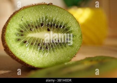 Freshly cut kiwi on wooden surface ready for cooking or snacking Stock Photo