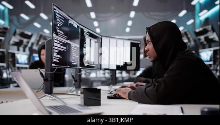 Hooded Programmer Stealing Secure Data And Information From Computer Screen. Stock Photo