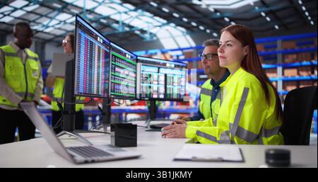 Managers In Office Oversee Warehouse Inventory Using Computer Software Daily. Stock Photo