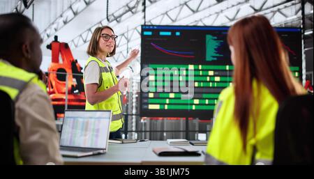 Diverse Group Of Workers Looking At Control Panel On TV. Stock Photo