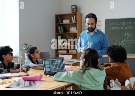 Educator Engaging Students in Technology-Enhanced Classroom Stock Photo