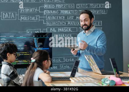 Teaching Programming in Classroom with Engaging Teacher Stock Photo