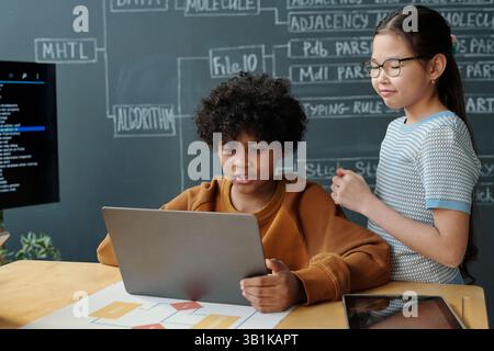 Collaborating on School Project with Laptop and Notes Stock Photo