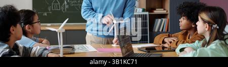 Teacher Explaining Wind Turbine Model to Students in Classroom Stock Photo