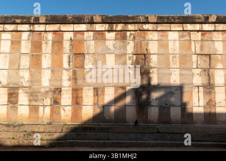 An old weathered temple wall painted in traditional red and white stripes in a village in Karnataka in South India. Stock Photo