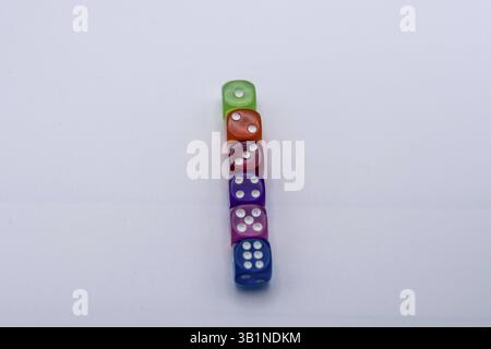 Vertical stack of colorful translucent dice on a light background Stock Photo