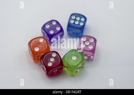 Colorful translucent dice arranged in a circle on a light surface Stock Photo