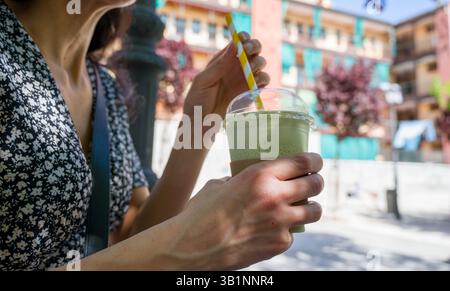 woman having iced matcha latte Stock Photo