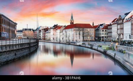 Dramatic sunset over Gammel strand with canal reflection in downtown Copenhagen skyline, Denmark Stock Photo